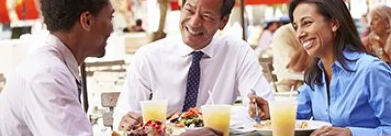 Tres personas disfrutando de una comida al aire libre.