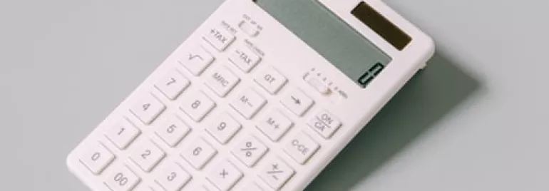 Calculadora blanca moderna sobre fondo gris.