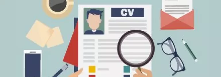 Manos sosteniendo un CV con lupa, taza de café y gafas.