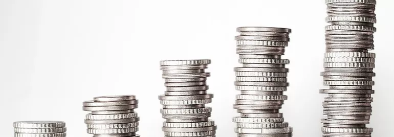 Varias pilas de monedas plateadas apiladas en aumento.