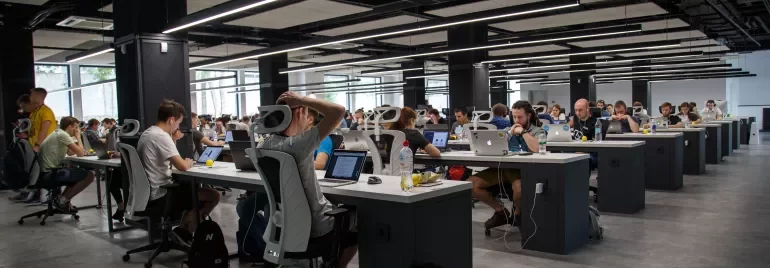 Oficina con personas trabajando en computadoras portátiles.