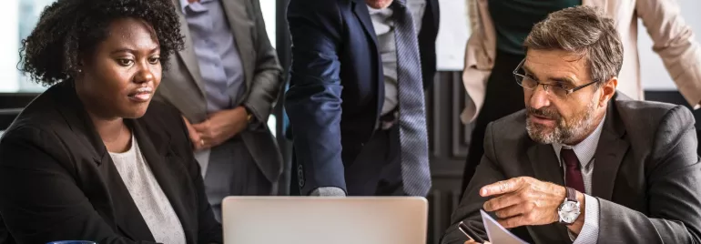 Grupo de personas en una reunión de trabajo frente a una computadora.