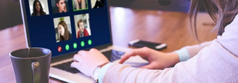 Persona usando una laptop para una videollamada con seis participantes.