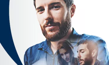 Hombre con barba y camisa azul con figuras superpuestas, fondo blanco.