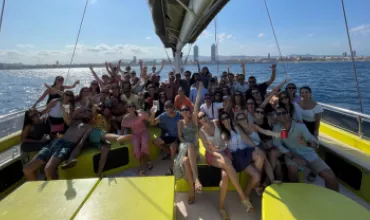 Grupo alegre en un barco disfrutando del día soleado en el mar.