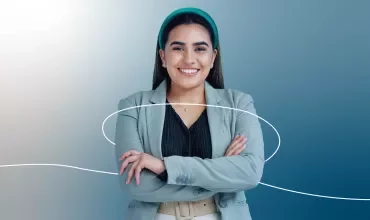 Una persona sonriendo con los brazos cruzados y fondo azul.