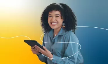 Persona sonriente con una tableta y fondo colorido.