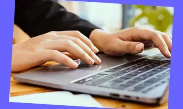 Close-up of hands typing on a laptop