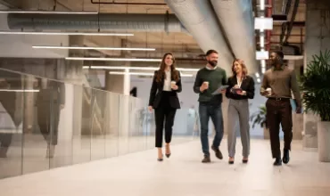 A group of people walking through office corridors