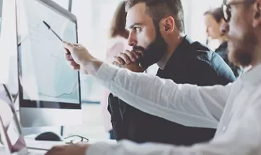 Personas trabajando juntas frente a una computadora.