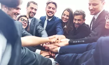 Grupo de personas unidas en un equipo.