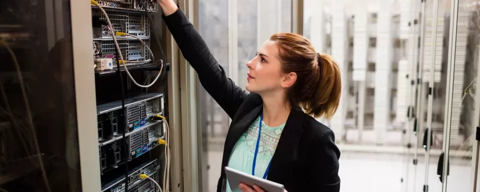 Persona revisando equipos en una sala de servidores