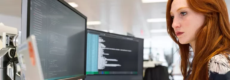 Persona trabajando en una computadora en una oficina moderna.