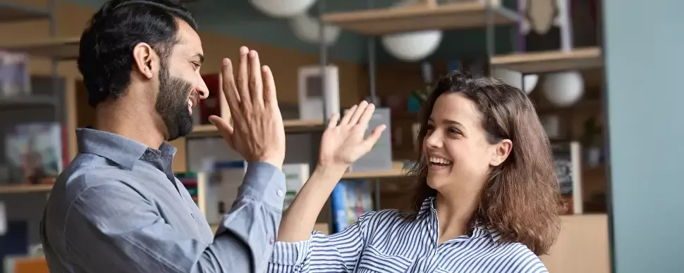 Hombre y mujer sonrientes chocando palmas