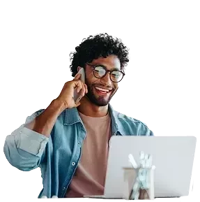 Un hombre en la oficina sentado en frente de un ordenador haciendo una llamada.