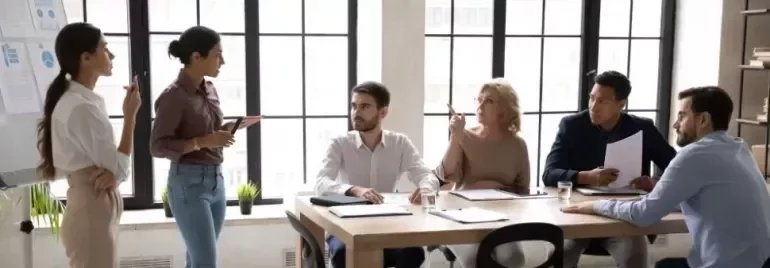 Equipo de trabajo satisfecho trabajando en un entorno de oficina colaborativo.