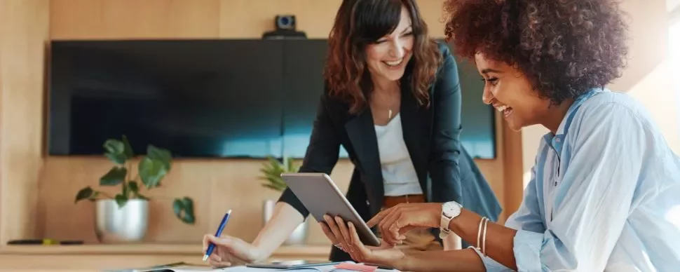 dos mujeres sonrientes tras escribir revisar las plantillas de seguimiento