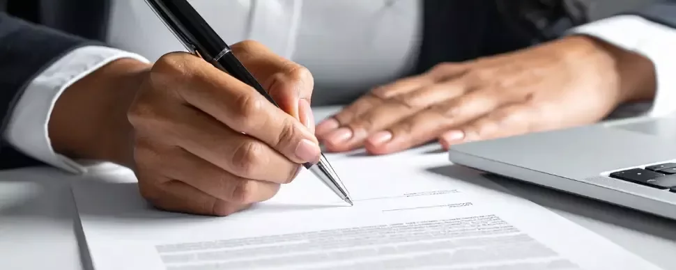 detalle de la mano de una persona firmando un contrato