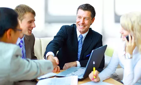 Personas en una reunión de negocios, estrechando manos.