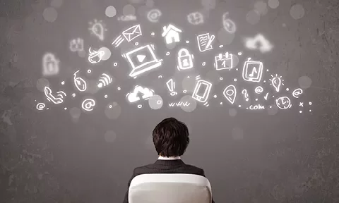 Persona mirando iconos digitales que flotan sobre un fondo gris.