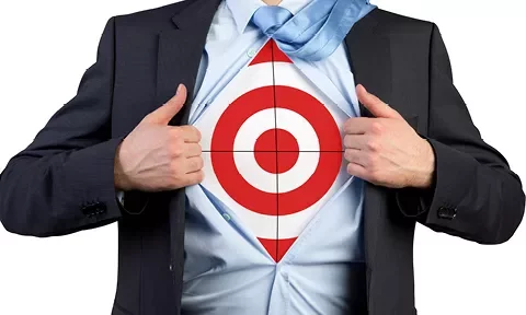Persona abriendo camisa para revelar un objetivo rojo debajo.