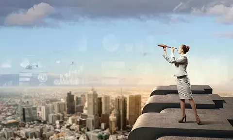 Persona con un telescopio de pie sobre una palabra gigante con una ciudad al fondo.