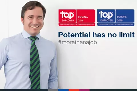 Persona sonriendo junto a premios de Top Employer España y Europa 2018.