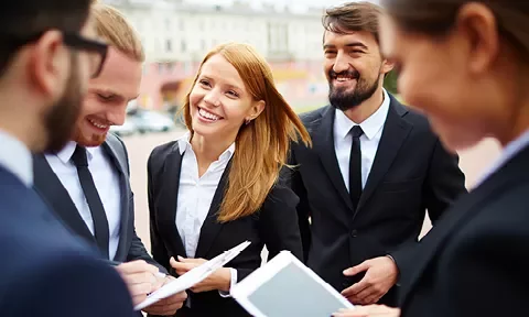 Grupo de profesionales sonrientes al aire libre.