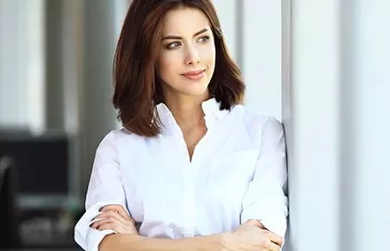 Persona sonriendo con una camisa blanca.