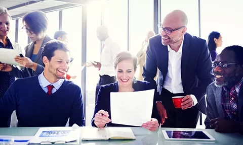 Grupo de personas trabajando en equipo en una oficina moderna.