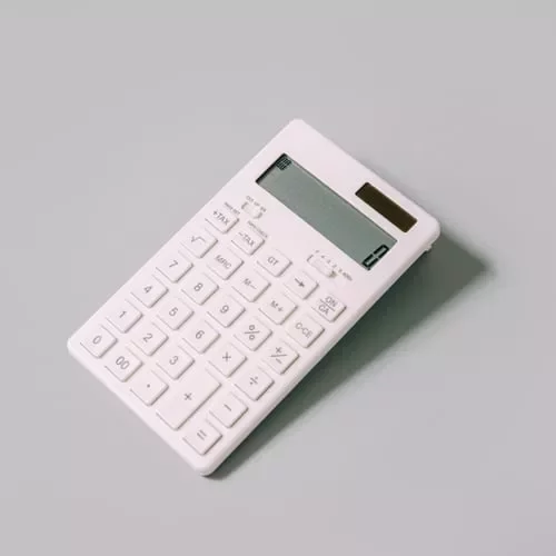 Calculadora blanca moderna sobre fondo gris.