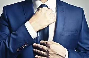 Persona ajustando una corbata azul.