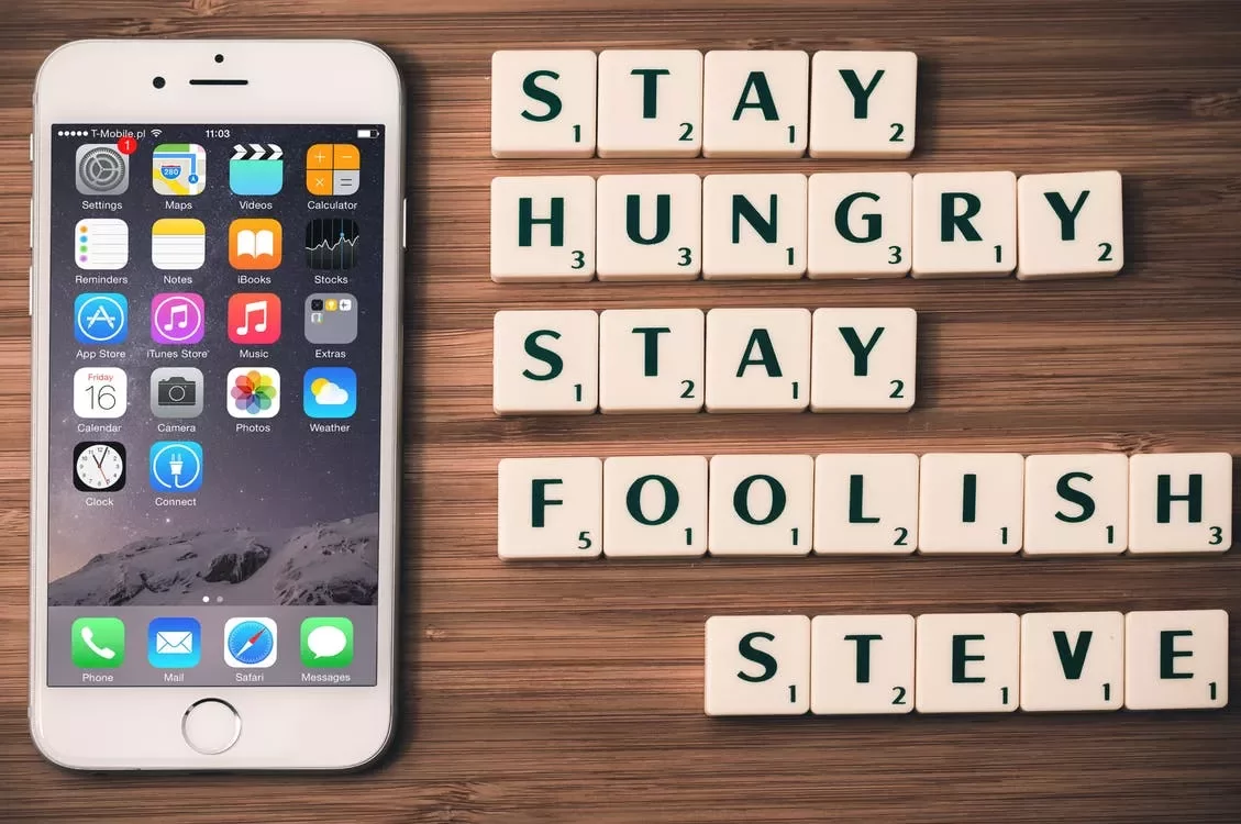 Teléfono junto a letras que forman la frase 'Stay hungry, stay foolish, Steve'.